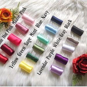 May include: A collection of 10 satin ribbon rolls in various colors, including red, maroon, hot pink, mauve pink, yellow green, sage green, mint blue, navy, lavender purple, white, gray, and black.