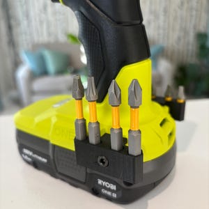 May include: A black 3D printed bit holder with five drill bits attached to a yellow and black Ryobi ONE+ 18V lithium-ion battery.