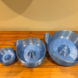 May include: A set of three ceramic mugs with a speckled, matte finish. The mugs are in shades of cream, light gray, and dark gray. Each mug has a simple, minimalist design, perfect for coffee or tea.