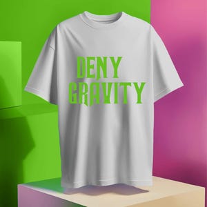 May include: White t-shirt with the text "DENY GRAVITY" printed in green.