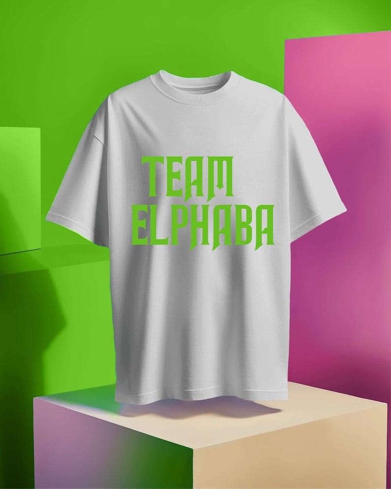 May include: White t-shirt with green text that reads "TEAM ELPHABA".