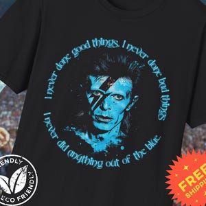 Może przedstawiać: Czarny T-shirt z niebiesko-białą ilustracją Davida Bowie. Wokół ilustracji nadrukowany jest tekst "I never done good things. I never done bad things. I never did anything out of the blue."