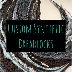 May include: A bundle of custom synthetic dreadlocks in black, blue, and white. The dreadlocks are decorated with beads and charms.