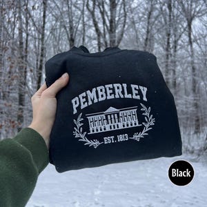 May include: Black hooded sweatshirt with a white graphic of a building with the text "Pemberley Est. 1813".