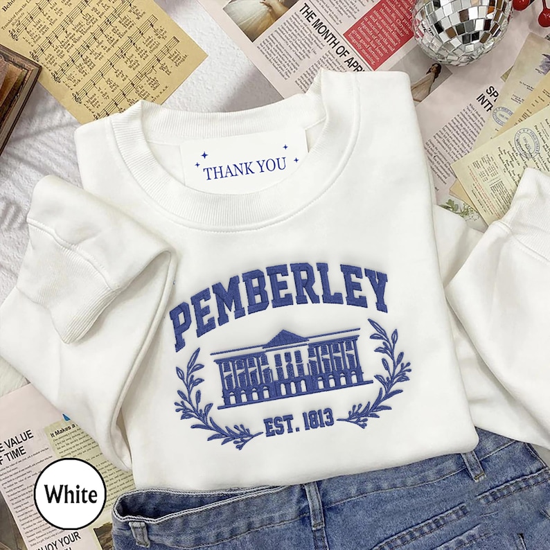 May include: White crewneck sweatshirt with a blue embroidered design of a building with the text "PEMBERLEY EST. 1813" and the words "THANK YOU" on a white tag.