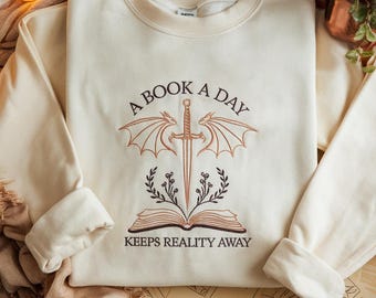 Sudadera bordada con dragón "Un libro al día", sudadera con temática de libros, camiseta bordada con dragón que aleja la realidad, camiseta con libro de fantasía