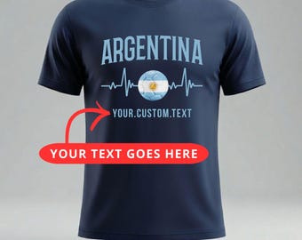 May include: Navy blue t-shirt with the word "ARGENTINA" in light blue above a soccer ball with the Argentinian flag design. The text "YOUR.CUSTOM.TEXT" is below the word "ARGENTINA". The text "YOUR TEXT GOES HERE" is in a red banner.