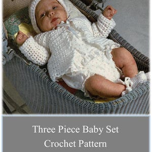 May include: A white crocheted baby set, including a sweater, bonnet, and booties. The set is laid out in a wicker basket.