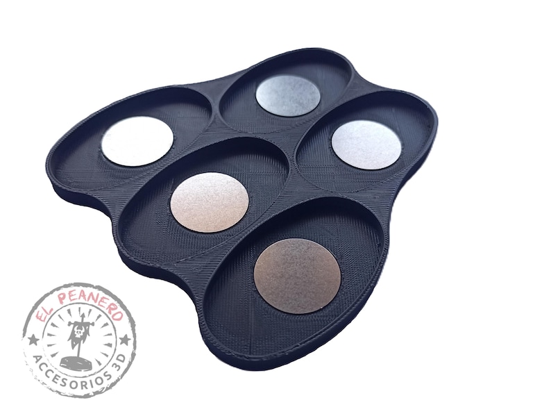 May include: Black plastic tray with six oval-shaped compartments. Each compartment has a round, metallic disc inside. The tray has a logo on the bottom that says "El Peanero Accesorios 3D".