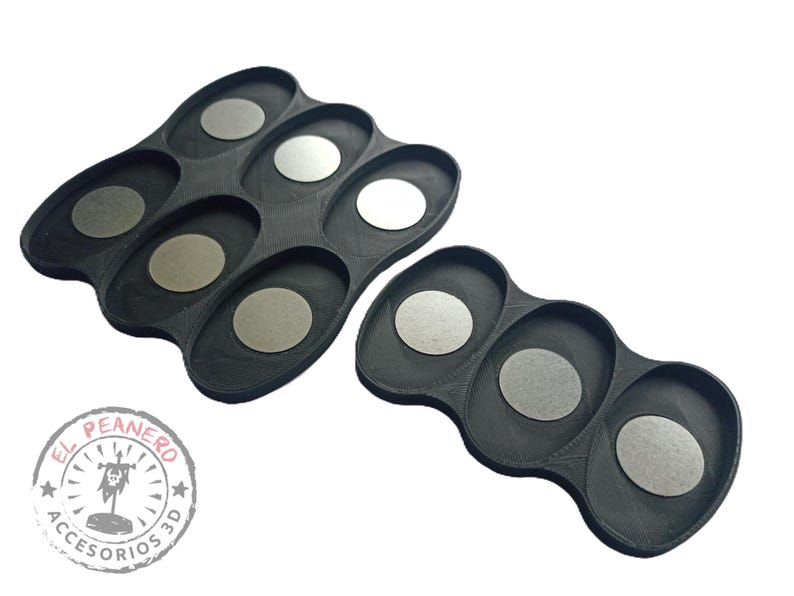 May include: Two black plastic trays with circular indentations for holding small round objects. The trays are designed for organizing and storing small items.