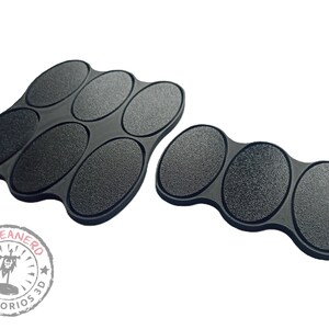 May include: Two sets of black oval-shaped paint trays. The larger set has six trays and the smaller set has three trays. Both sets are made of a textured material.