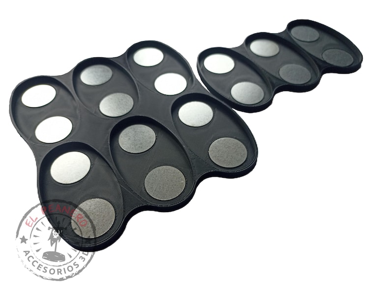 May include: Two black plastic trays with circular indentations for holding small items. The trays are designed to hold paint pots or other small containers.