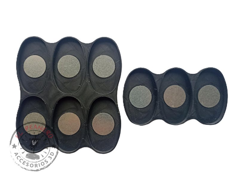May include: Two black plastic trays with circular indentations for holding small round objects. The larger tray has six indentations and the smaller tray has three indentations.
