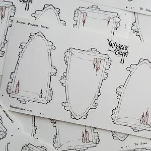 May include: A stack of white planner stickers with a black outline of an arched doorway with candles. The stickers have the text "Vampire's Crypt" and "Alcove Planner Boxes" printed on them.