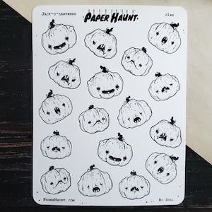 May include: A sheet of 18 black and white jack-o-lantern stickers with various facial expressions. The stickers are on a white background and have the text "Paper Haunt" and "Jack-O-Lanterns" printed on the sheet.