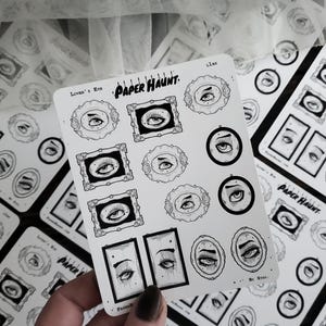 May include: A sheet of black and white stickers featuring various eye designs. The stickers are arranged in a grid pattern and include a variety of styles, including eyes with eyelashes, eyes with stars, and eyes with frames. The stickers are labeled "Paper Haunt" and "Lover's Eye".