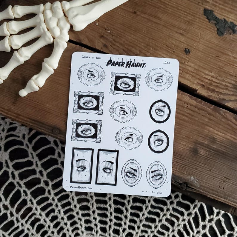 May include: A sheet of black and white stickers featuring various eye designs. The stickers are labeled "Lover's Eye" and "Paper Haunt." The text "By Stag" is at the bottom of the sheet.