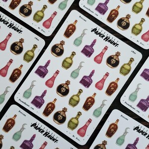 May include: A sheet of colorful potion stickers with a skull and crossbones design. The stickers are on a white background with the text "Paper Haunt" and "Potions" printed on the sheet.