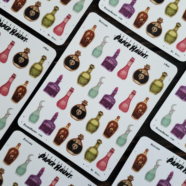 May include: A sheet of colorful potion stickers with a skull and crossbones design. The stickers are on a white background with the text "Paper Haunt" and "Potions" printed on the sheet.