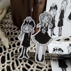 May include: Two black and white illustrations of girls with pumpkin heads. The girls are wearing dresses and have long hair. The text "Pumpkin Girls" is visible in the image.