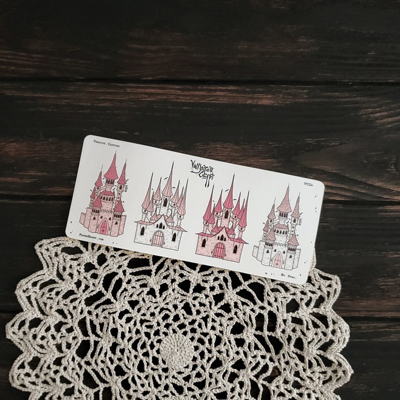 May include: A sheet of stickers featuring four different illustrations of pink and white castles with whimsical details. The stickers are labelled "Vampire's Crypt" and "Printed Castles".