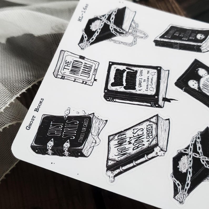 May include: A set of nine black and white stickers featuring illustrations of books with spooky themes. The titles include "The Haunted Library", "Ghost Stories", "A Ghost's Guide to Exorcising the Living", "Where  My Bones?", and "A Ghost's Lament".