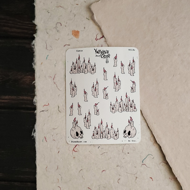 May include: A sheet of stickers featuring various illustrations of candles with flames. The stickers are white with black outlines and red flames. The sheet also includes two skull illustrations with candles on top. The text "Yumeiro Craft" is printed at the top of the sheet.