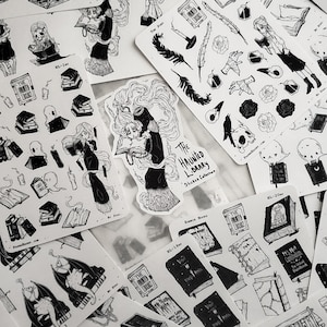 May include: A set of black and white stickers featuring illustrations of books, ghosts, and a woman reading a book. The stickers are part of a collection called "The Haunted Library Sticker Collection".