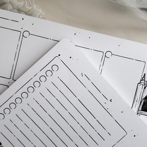 Op de afbeelding: Een witte planner met een zwart-wit ontwerp. De planner heeft een sectie voor to-do-lijsten, notities en een kalender. Het ontwerp bevat sterren, cirkels en lijnen.