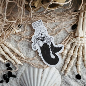 Gothic pirate mermaid sticker by artist White stag for Paper Haunt Stationery & Co on sand with a fishing net.