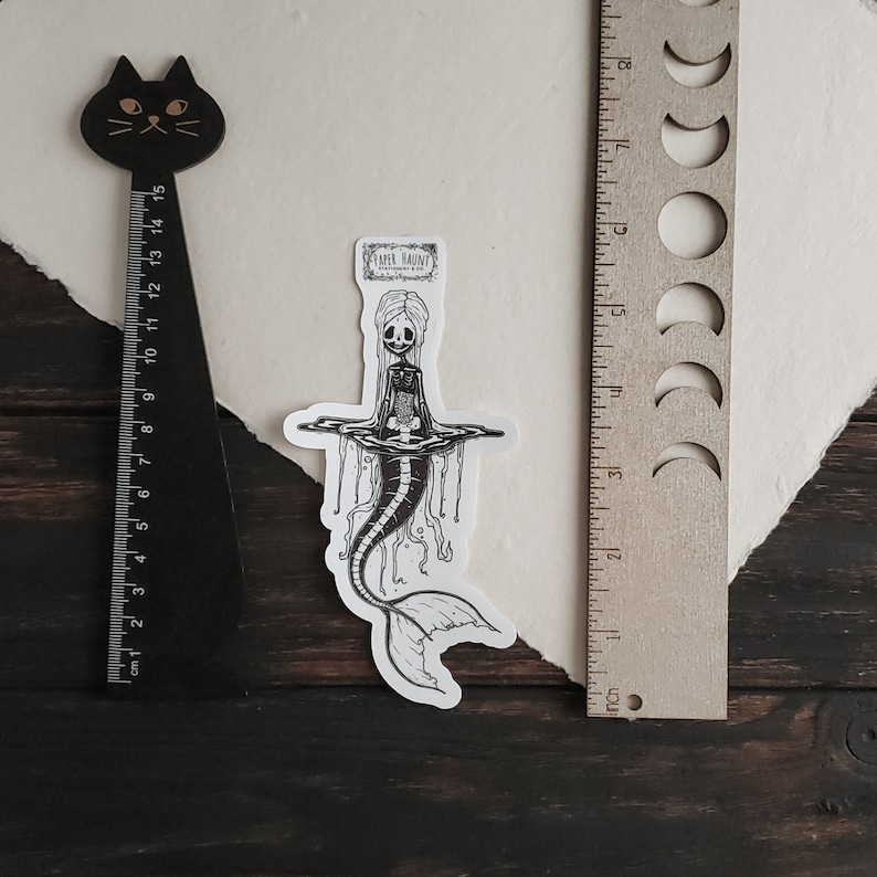 Size and measurement reference for Spooky cute goth Jelly bones mermaid skeleton emerging from water, a sticker Featuring a Mermaid with Translucent skin with visible skeleton and organs.