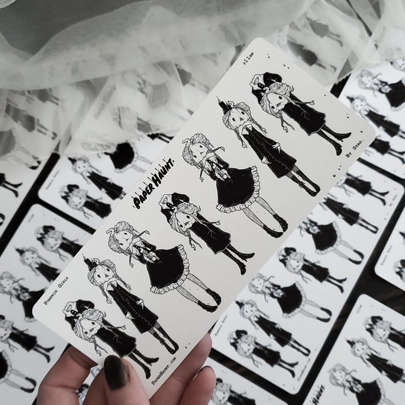 May include: A sheet of black and white stickers featuring illustrations of girls in dresses. The stickers are labeled "Paper Haunt" and "By Srea".