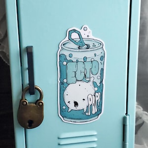 Può includere: Un adesivo con un design di lattina di soda dei cartoni animati con la scritta "ECTO" e un simpatico personaggio. La lattina è azzurra con dettagli bianchi, su un armadietto azzurro.