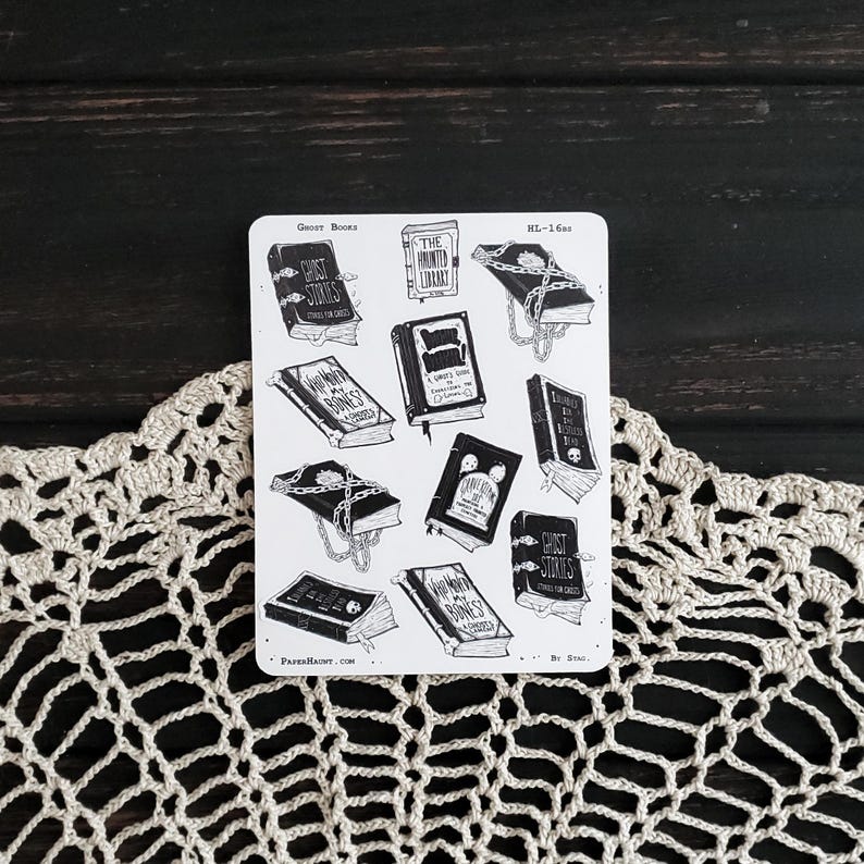 May include: A sheet of black and white stickers featuring illustrations of spooky books with titles like "Ghost Stories", "The Haunted Library", and "Within My Bones". The stickers are on a white background and have a vintage aesthetic.