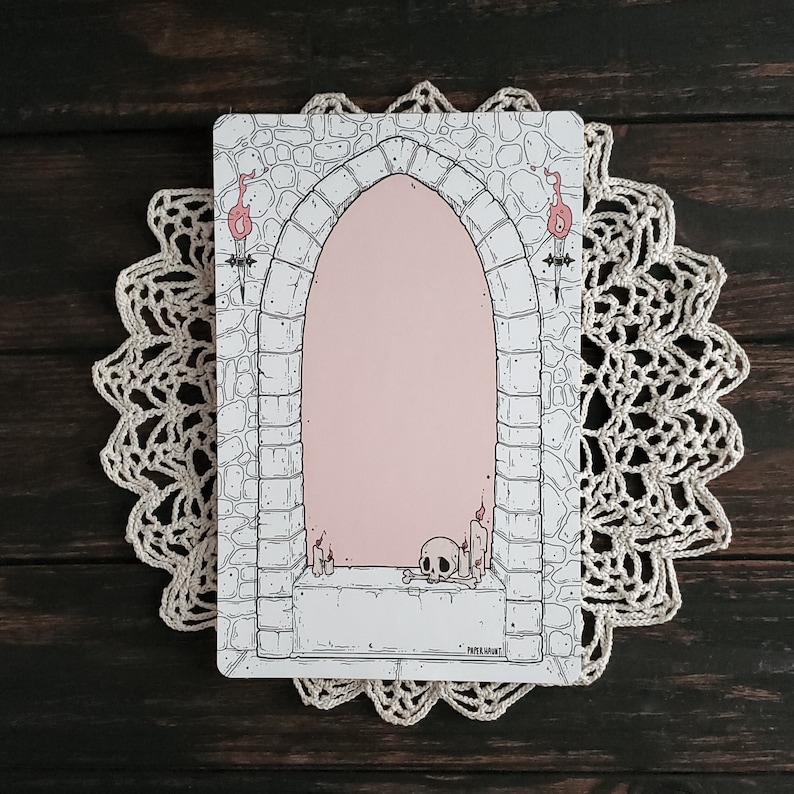 Pode incluir: Uma ilustra&ccedil;&atilde;o em preto e branco de um arco de pedra com um interior rosa. O arco tem duas velas acesas de cada lado e uma caveira com ossos na base. O texto "PAPER MAUNT" est&aacute; na parte inferior da imagem.
