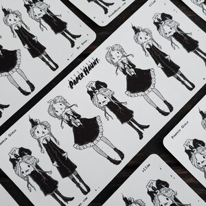 May include: A set of black and white stickers featuring illustrations of pumpkin girls with candles. The stickers are on a white background and have the text "Paper Haunt" and "By Strao" printed on them.