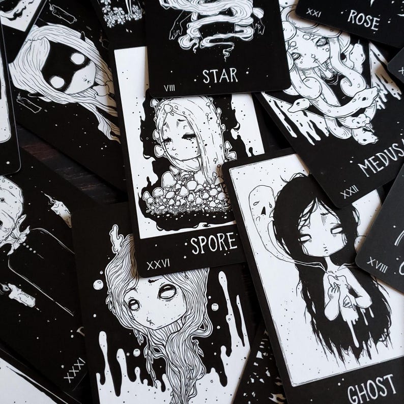 May include: Black and white tarot cards with illustrations of various characters and symbols. The cards feature numbers and names such as "Star", "Spore", "Ghost", "Medusa", and "Rose".