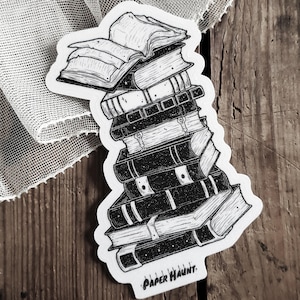 May include: A black and white illustration of a stack of books with a book open on top. The books are stacked in a tower and have a vintage, worn look. The text "PAPER HAUNT." is at the bottom of the image.