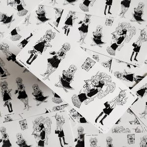 May include: A set of black and white stickers featuring illustrations of skeletons in various poses, including reading books. The stickers are on a white background and include the text "The Haunted Library" and "Library Residents".