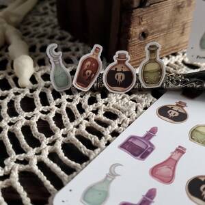 May include: A sheet of stickers featuring various potion bottles with different colored liquids and designs. The bottles have a whimsical, gothic aesthetic.