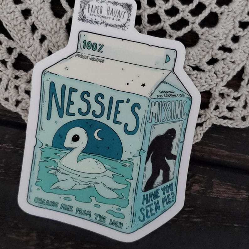 K&ouml;nnte beinhalten: Eine Cartoon-Illustration eines Milchkartons mit den Worten "Nessie's Missing" auf der Vorderseite. Der Karton ist blau und wei&szlig; mit einem Bild des Seeungeheuers von Loch Ness und eines Bigfoot. Der Text auf dem Karton lautet "Organic Milk from the Loch" und "Warning: May Contain Fish".
