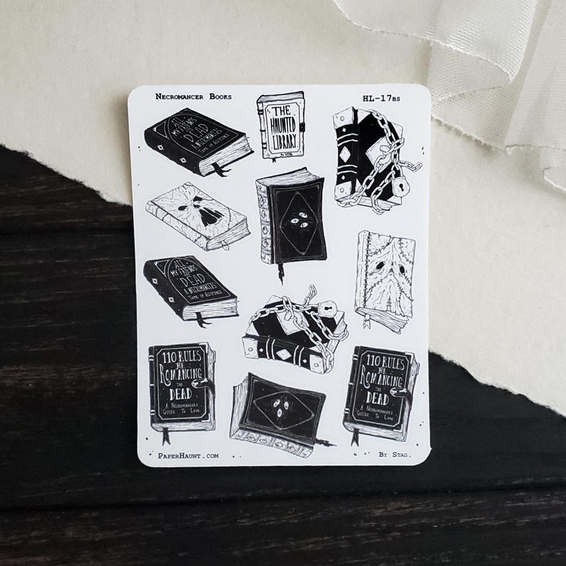 May include: A sheet of stickers featuring black and white illustrations of books with titles like "The Haunted Library", "All the Dead", and "110 Rules for Summoning the Dead". The stickers are on a white background with the text "Necromancer Books" and "HL-1785" at the top.