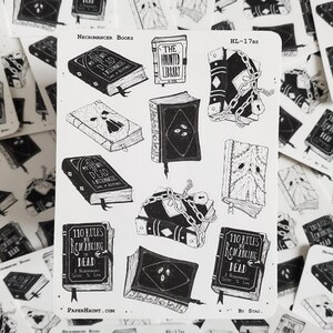 May include: A sheet of black and white stickers featuring illustrations of books with titles like "All My Friends Are Dead", "The Haunted Library", and "110 Rules for Romancing the Dead". The stickers are designed in a gothic style with chains, skulls, and other spooky details.