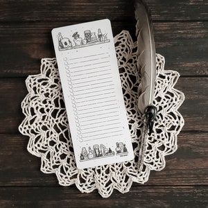 Puede incluir: Una lista de verificaci&oacute;n blanca con una ilustraci&oacute;n en blanco y negro de un estante con botellas de pociones y una calavera. La lista de verificaci&oacute;n tiene 30 l&iacute;neas y un c&iacute;rculo al lado de cada l&iacute;nea. El texto "PAPER & MINT" est&aacute; en la parte inferior de la lista de verificaci&oacute;n.