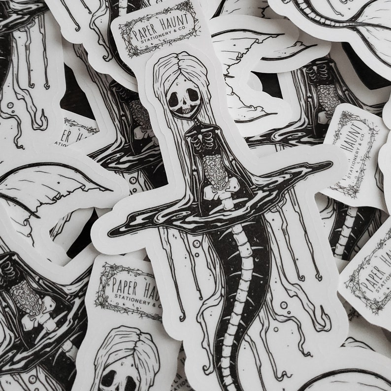 Spooky cute close up of a pile of goth Jelly bones mermaid skeleton emerging from water, a sticker Featuring a Mermaid with Translucent skin with visible skeleton and organs.