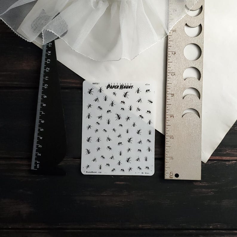 May include: A sheet of clear sticker paper with black ant silhouettes. The sheet is labeled "Paper Haunt" and has the text "Parts 1" and "A1.10".