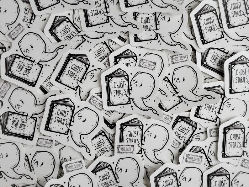 May include: A collection of black and white stickers featuring a ghost reading a book with the text "Ghost Stories".