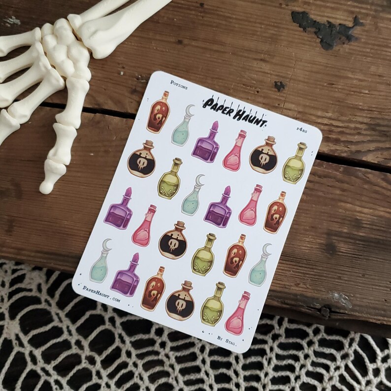 May include: A sheet of stickers featuring various colorful potion bottles with skull and crossbones designs. The stickers are labeled "Paper Haunt."