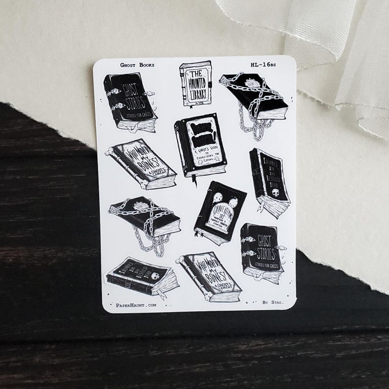 May include: A sheet of black and white stickers featuring illustrations of books with spooky titles like "Ghost Stories", "The Haunted Library", and "Who Wears My Bones?" The stickers are designed for use in planners, journals, and other paper crafts.