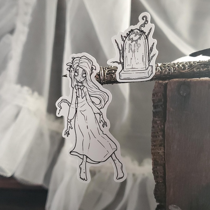 May include: Black and white line art sticker set featuring a spooky girl in a dress and a tombstone with the inscription "RIP".